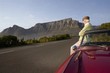 Photo: Senior man admires view leaning on vintage racing car on Signal Hill, Cape Town, South Africa Senior man admires view leaning on vintage racing car on Signal Hill, Cape Town, South Africa