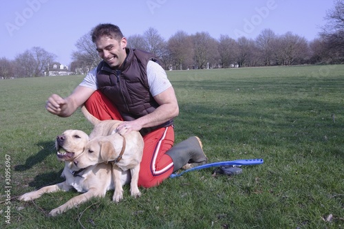 Photo: A man and his two dogs in the park A man and his two dogs in the park