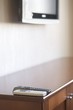 Photo: Two controls positioned on the corner of a cabinet with a television in the background Two controls positioned on the corner of a cabinet with a television in the background