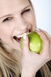 Foto: Junge Frau beisst genussvoll und lachend in Apfel, hoch Junge Frau beisst genussvoll und lachend in Apfel, hoch