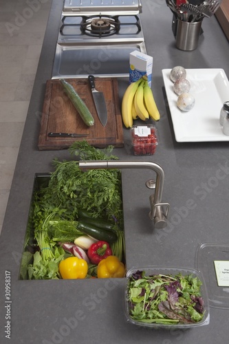 Photo: Fresh food preparation on kitchen counter with sink Fresh food preparation on kitchen counter with sink