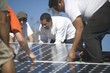 A group of men laying down a large solar panel