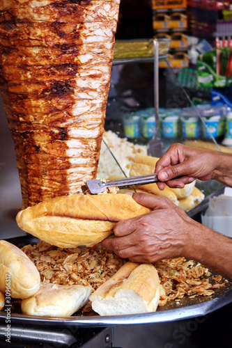 Photo: Hand filling up a full bread with kebab Hand filling up a full bread with kebab