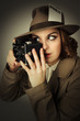 Foto: Retro looking model holding a vintage camera. Retro looking model holding a vintage camera.