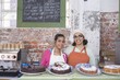 Catering assistants stand side by side in service area of canteen