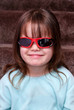 Foto: Young girl looking cool with sunglasses on indoors Young girl looking cool with sunglasses on indoors