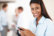 Business woman texting with team in background