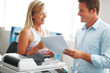 Two happy colleagues having a friendly chat in office