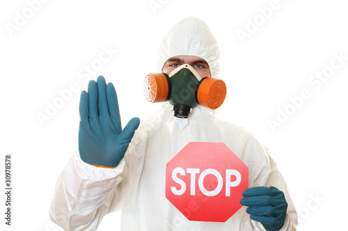 Photo: Man in protective suit with a sign STOP Man in protective suit with a sign STOP