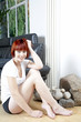 Young female sitting in front of sofa relaxing.