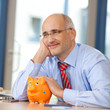 entspannter geschäftsmann mit sparschwein
