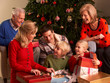 Three Generation Family Opening Christmas Gifts At Home