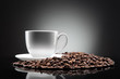 white cup with coffee beans on black