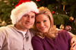 Couple Relaxing In Front Of Christmas Tree