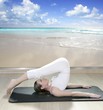 black mat yoga woman window view of tropical beach