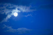 full moon over blue sky at a summer night with some clouds