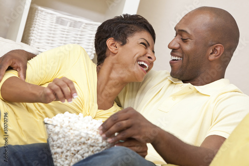 Photo: Happy African American Couple Eating Popcorn Watching Movie Happy African American Couple Eating Popcorn Watching Movie