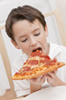 Photo: Young Boy Child Eating Slice of Pizza Young Boy Child Eating Slice of Pizza
