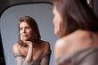 Femme pensive devant miroir