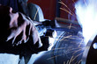 worker weld metal in factory and sparks