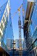 Huge crane rising between two buildings under construction