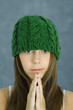 Teen girl wearing knit hat, hands clasped, portrait