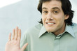 Man shrugging shoulders and holding up palm, portrait