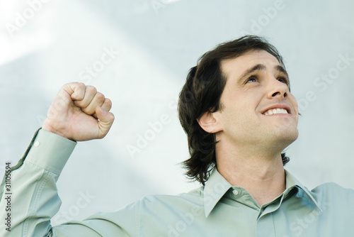 Photo: Man clenching fist, looking up, portrait Man clenching fist, looking up, portrait
