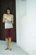 Woman standing reading book, full length portrait