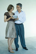 Mature couple standing, man handing woman gift, full length portrait