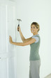 Woman hammering nail into door
