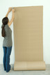 Woman stapling corrugated cardboard to wall
