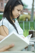 Young woman, book in blurred foreground