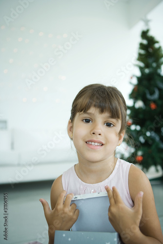Foto: Girl opening Christmas presents Girl opening Christmas presents