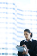 Young businesswoman holding binder, writing
