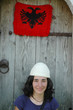 Albanian girl with traditional hat and flag of Albania