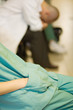 Photo: Medical worker with hands in pockets, doctor with head down in background, cropped view Medical worker with hands in pockets, doctor with head down in background, cropped view