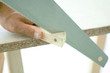 Man cutting corner off piece of wood, close-up