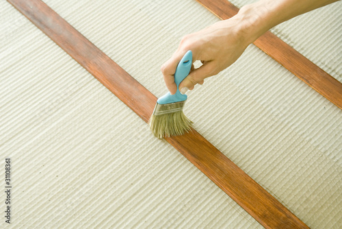 Photo: Woman staining piece of wood, close-up of hand Woman staining piece of wood, close-up of hand