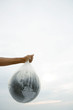 Man holding globe in plastic bag, cropped view