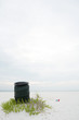 Garbage can on beach, litter lying on the ground nearby