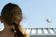 Little girl watching heron, over the shoulder view, focus on background