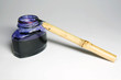 Reed pen and bottle of indigo ink, close-up