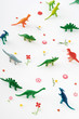 Plastic dinosaurs surrounded by fake flowers, high angle view