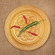 Red and green peppers in a beautiful wooden plate.