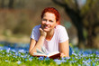 frau liest ein buch auf einer blumenwiese
