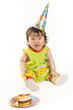 First birthday. Pretty little girl in a cap with a birthday cake