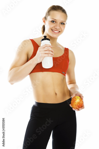 Photo: Sports woman holding an apple and bottle of water Sports woman holding an apple and bottle of water