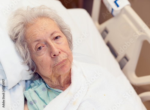Photo: Elderly 80 year old woman with Alzheimer in a hospital bed Elderly 80 year old woman with Alzheimer in a hospital bed