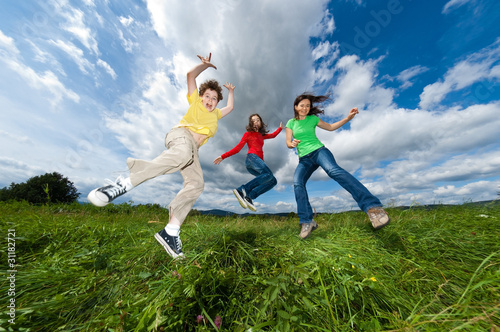 Photo : Active family - mother and kids jumping outdoor Active family - mother and kids jumping outdoor